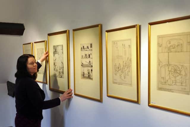 FUN WITH ART: Laura Farrell, from Nunnington Hall, hangs illustrations by William Heath Robinson. PIC: Bruce Rollinson