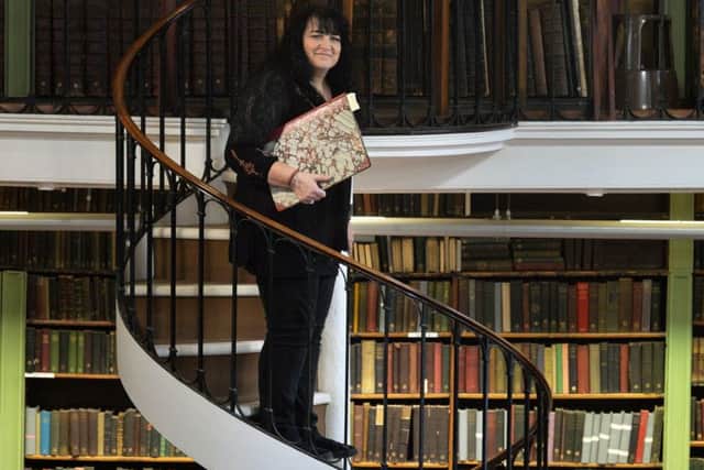 SPIRAL STAIRCASE:  Librarian Jane Riley with a bound volume.