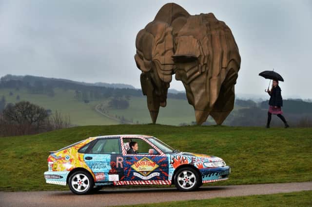 DRIVING AMBITION: Kerry Chase at the wheel of the car next to Caldera by Tony Cragg. PIC: Bruce Rollinson