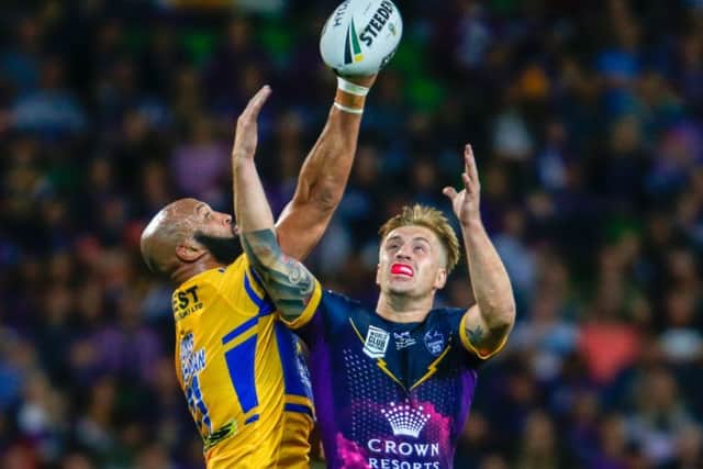 Jamie Jones-Buchanan of Leeds Rhinos and Cameron Munster of Melbourne Storm contest for the ball.