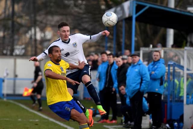 Callum McFadzean, of Guiseley, keeps an eye on the ball in front of Maidenhead's Remy Clerima. PIC: James Hardisty