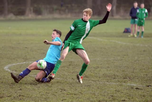 New Pudsey's Brodhi Wilkinson challenges  Glen Hewitt of Leodis in the West Riding County FA Sunday Trophy quarter-final. PIC: Tony Johnson