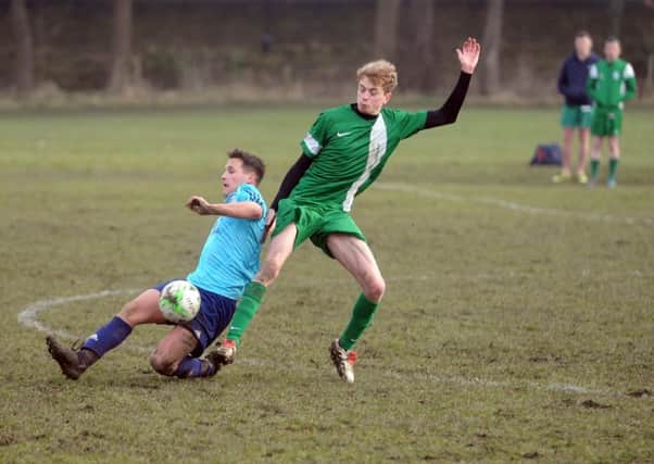 New Pudsey's Brodhi Wilkinson challenges  Glen Hewitt of Leodis in the West Riding County FA Sunday Trophy quarter-final. PIC: Tony Johnson