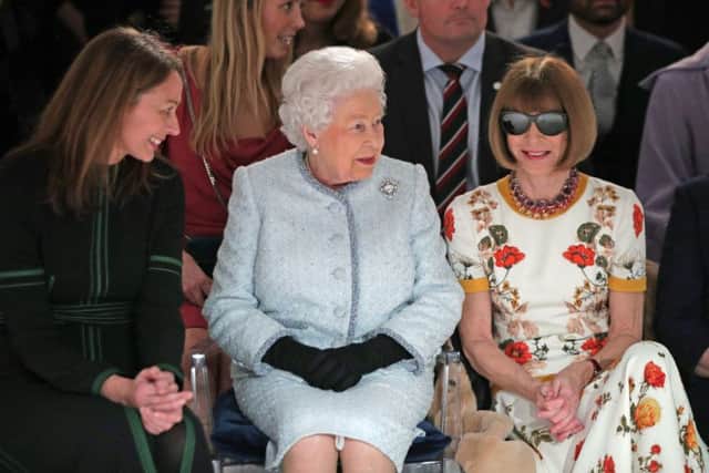 ALL SMILES NOW: Queen Elizabeth II sits next to Anna Wintour (right) and Caroline Rush, chief executive of the British Fashion Council (BFC) (left) as they view Richard Quinn's runway show before presenting him with the inaugural Queen Elizabeth II Award for British Design as she visits London Fashion Week's BFC Show Space in central London. Yui Mok/PA Wire