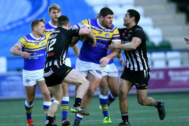 Mitch Garbutt is tackled by the Widnes Vikings defence.