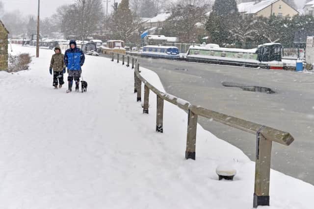 Dog walker's brave the snow on the Leeds Liverpool Canal at Five Rise Locks.