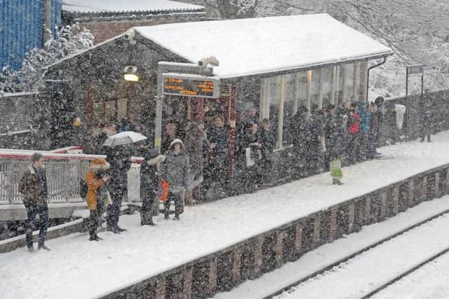 Commuters at New Pudsey train station stand waiting for a train to Leeds in heavy snow this morning. Picture Tony Johnson.