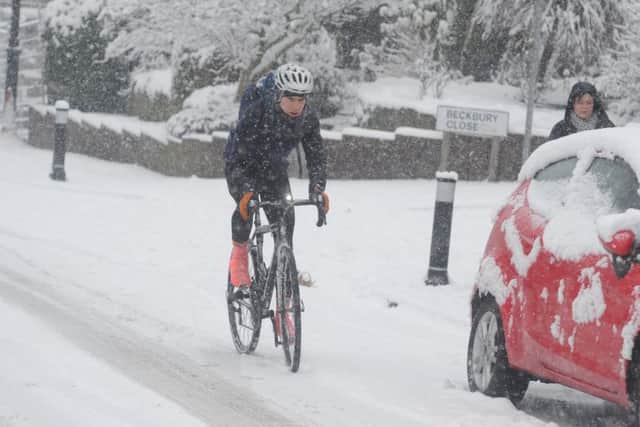 A cyclist in Farsley battles against the heavy snowfall early this morning. Picture Tony Johnson.