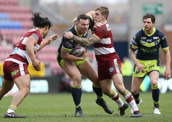 Wakefield Trinity's Keegan Hirst is tackled by Wigan Warriors Taulima Tautai (left) and Sam Powell (right) during the Betfred Super League match at the DW Stadium, Wigan. PIC: Martin Rickett/PA Wire