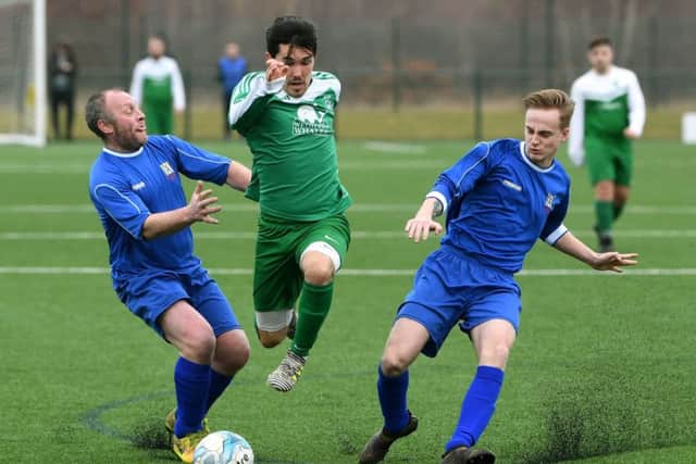 Sporting Pudsey's Adam Shaw gets away from Wayne Johnson and Billy Smith, of Harehills WMC during Sunday's Leeds Combination League Division One encounter played at the West Riding County FA HQ, Woodlesford. PIC: Jonathan Gawthorpe