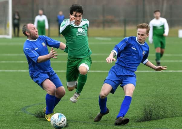 Sporting Pudsey's Adam Shaw gets away from Wayne Johnson and Billy Smith, of Harehills WMC during Sunday's Leeds Combination League Division One encounter played at the West Riding County FA HQ, Woodlesford. PIC: Jonathan Gawthorpe