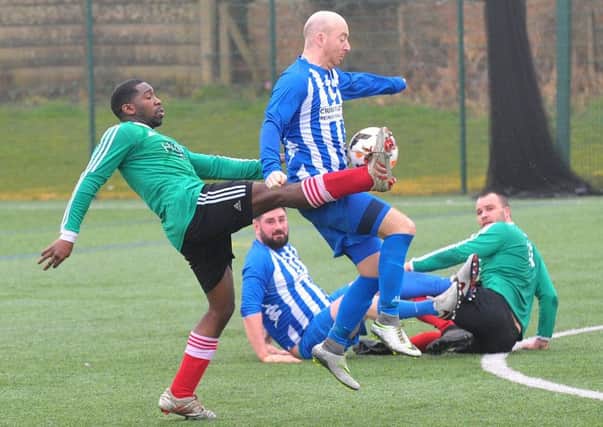 Dom Rawlings, of St Nicholas, gets in a foot to stop Ryan Dawson, of Beeston Juniors, during Saturday's Yorkshire Amateur League Premier Division encounter. PIC: Steve Riding