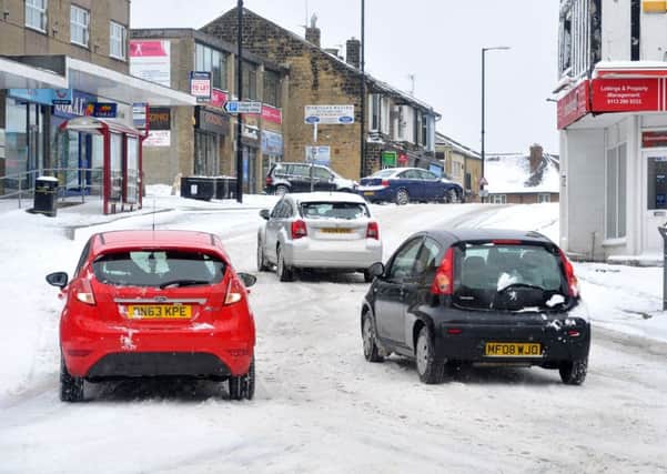 Cars struggle to negotiate Lidget Hill in Pudsey in today's snow. Picture: Tony Johnson.
