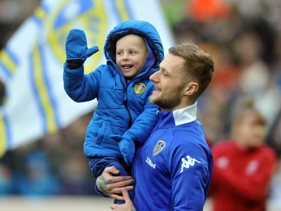 Young Leeds United fan Toby Nye with Whites captain Liam Cooper.