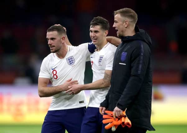 John Stones, centre, with England team-mates Jordan Henderson, left, and  Joe Hart after Friday's win in Holland.