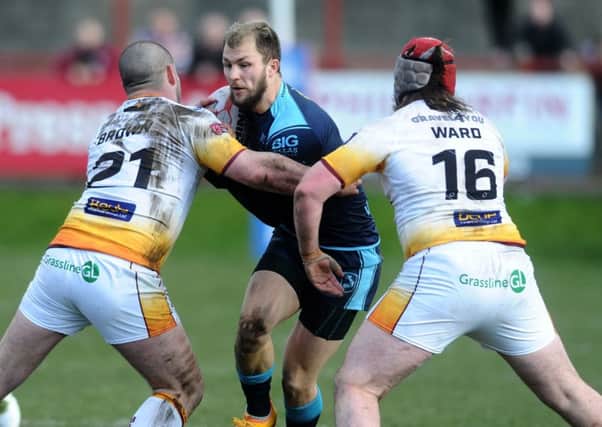 Featherstone Rovers' Luke Briscoe is tackled by Batley's James Brown and Michael Ward.