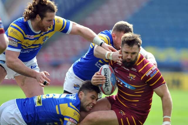 Paul Clough is tackled by the Leeds Rhinos' defence. Picture Tony Johnson.