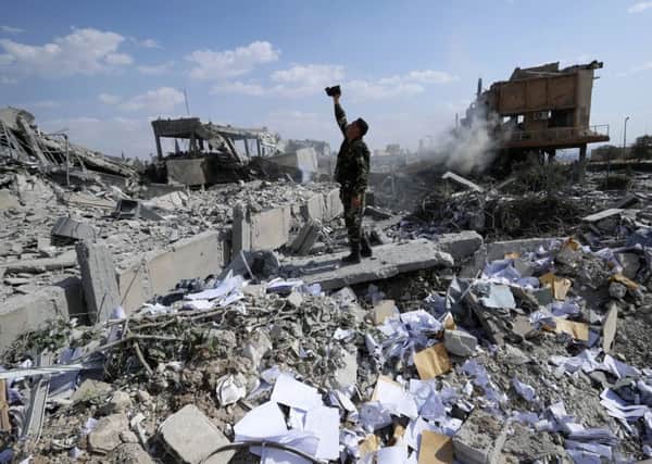devastation: A Syrian soldier films the damage of the Syrian Scientific Research Centre which was attacked by US, British and French military strikes to punish President Bashar Assad for a suspected chemical attack.