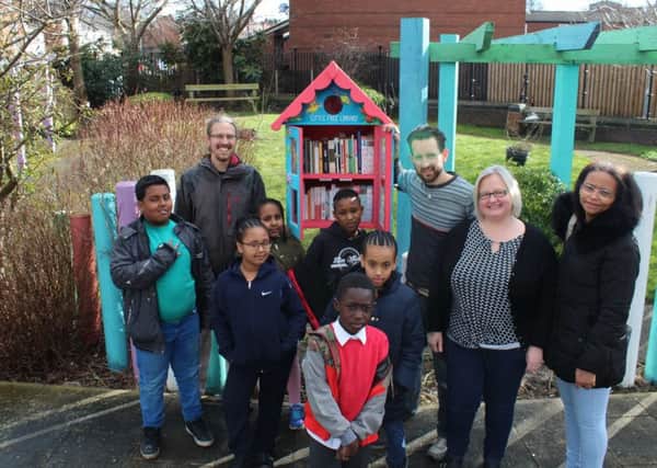 COMMUNITIES UNITE: Some of the volunteers at the new free library outside the Hillside Enterprise.