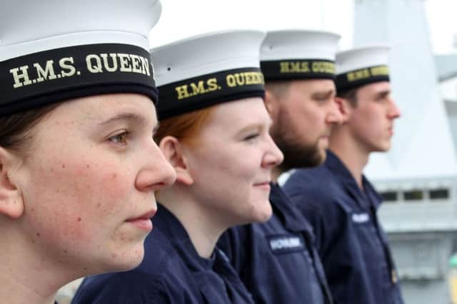 MAKING WAVES: Members of the ships company assemble on the bridge wing  of Britains new supercarrier HMS Queen Elizabeth.