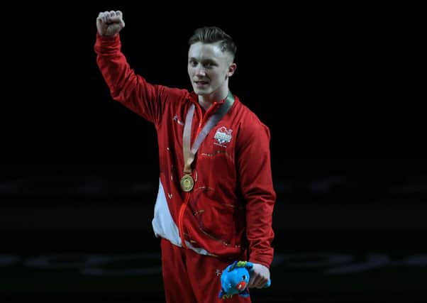 England's Nile Wilson celebrates winning a gold medal in the Men's Individual All-Round Final with coach Ben Collie at the Coomera Indoor Sports Centre during day three of the 2018 Commonwealth Games in the Gold Coast, Australia.  (Pictures: Mike Egerton/PA Wire)