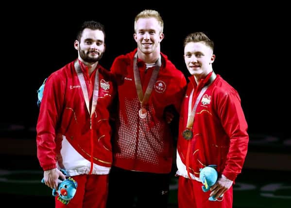 England's Nile Wilson (right) with his gold medal, Canada's Cory Paterson with his silver medal (centre) and England's James Hall with his bronze medal won in the Men's Horizontal Bar at the Commonwealth Games.