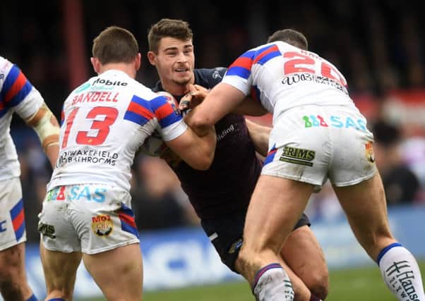 Stevie Ward is tackled by Wakefield Trinity's Tyler Randell and Keegan Hirst.