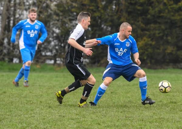 AFC Travellers' Danny Hurley makes his move against James Benn, of Churwell Blues. PIC: James Hardisty