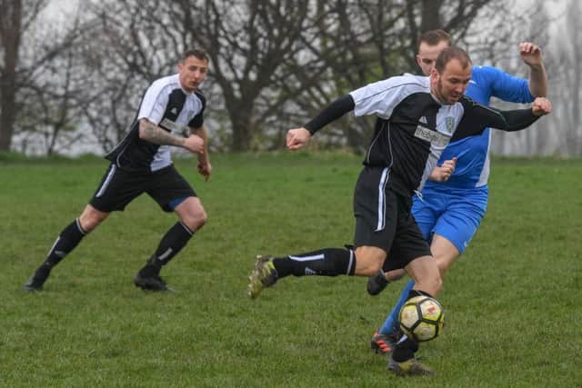 AFC Travellers' Gordon Booth takes control under pressure from Sam Bullers, of Churwell Blues. PIC: James Hardisty