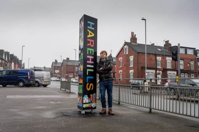 Artist Ian Kirkpatrick, next to the Harehills sign which he helped to design. Pic: James Hardisty
