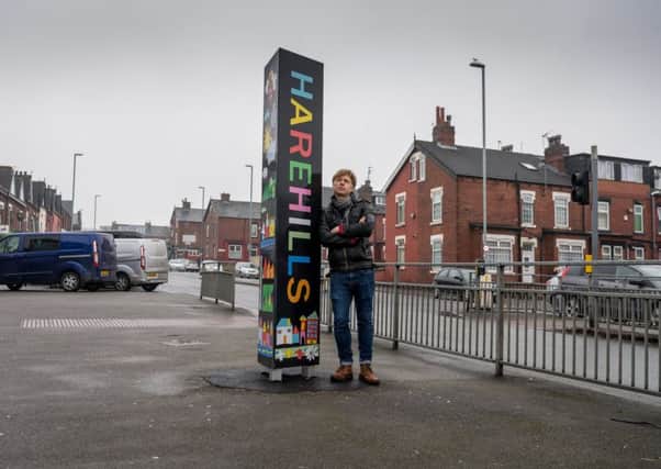 Artist  Ian Kirkpatrick, next to the Harehills sign which he helped to design. Pic: James Hardisty