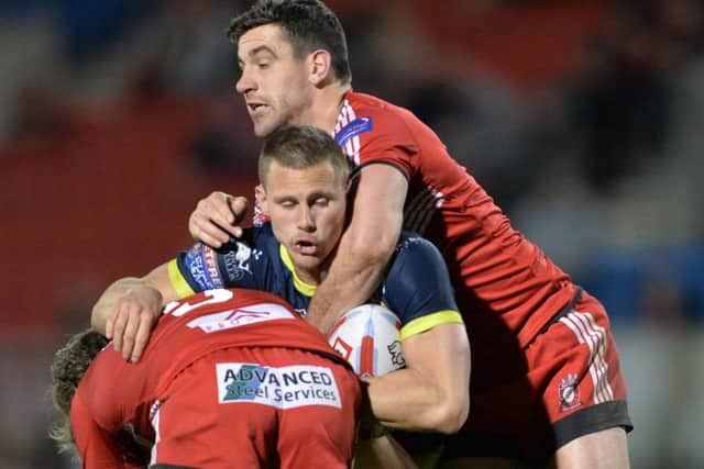 Kyle Wood is held by Logan Tomkins and Tyrone McCarthy.
