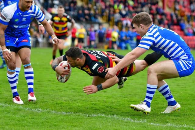 Dewsbury's Paul Sykes beating Ben Kaye, of Halifax, to score. PIC: Paul Butterfield