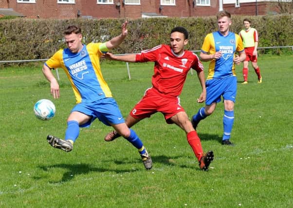 Jody Lazenby, of Horsforth St Margaret's Reserves, beats Shire Reserves' Dion Ellis to the ball. PIC: Steve Riding