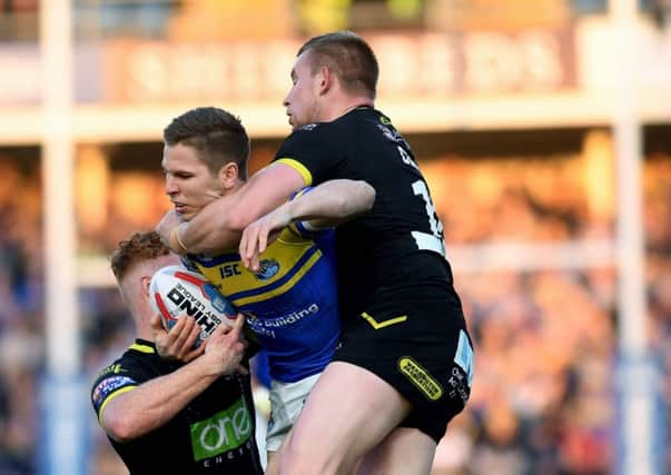 TOUGH NIGHT: Leeds Rhinos' Matt Parcell is tackled by Wolves Harvey Livett and Mike Cooper.
 Picture: Jonathan Gawthorpe