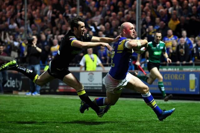 OVER THE LINE: Leeds Rhinos' Carl Ablett gets away from Wolves Stefan Ratchford to score. Picture: Jonathan Gawthorpe.