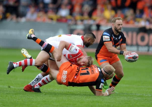 TAKE THAT: Castleford Tigers' Oliver Holmes is tackled by Sait Helens' Danny Richardson and Dominique Peyroux. Picture: Tony Johnson.
