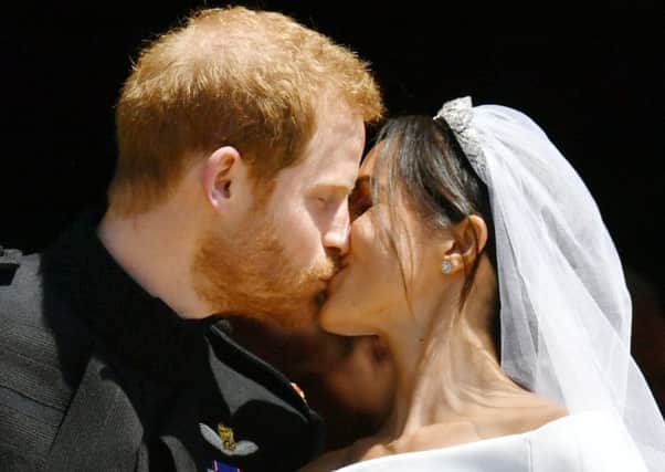Prince Harry and Meghan Markle kiss on the steps of St George's Chapel in Windsor Castle. PIC: PA