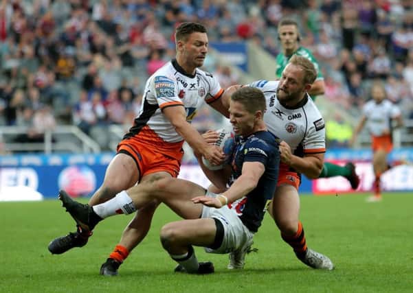 Castleford Tigers Paul McShane and Jy Hitchcox tackle Leeds Rhinos' Matt Parcell.