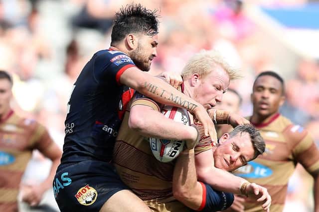 Huddersfield Giants' Matthew English is tackled by Wakefield Trinity's Justin Horo and Matty Ashurst