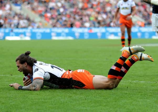 Castleford Tigers' Alex Foster dives in to score against Leeds Rhinos.