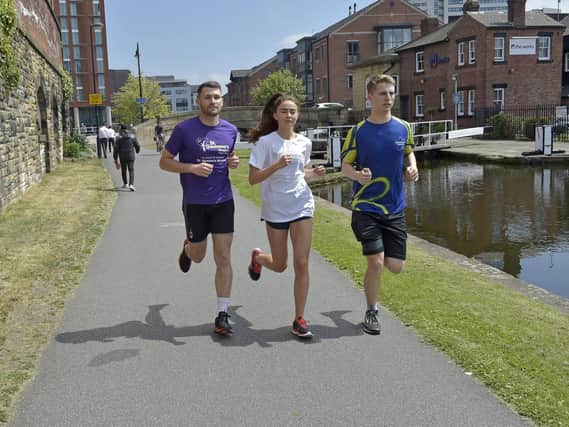 On a mission: Jamie Sheard, left, Lena Hughes and Sam Gibson, right, who will tomorrow set off from Liverpool on their 127-mile journey back to Leeds, in aid of charity.