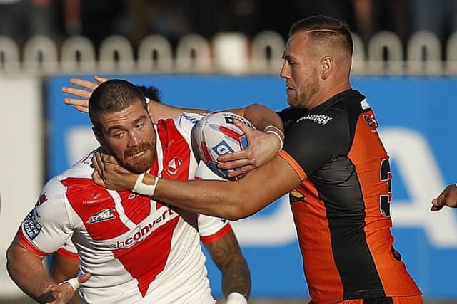 St Helens' Kyle Amor is tackled by Castleford Tigers' Liam Watts.