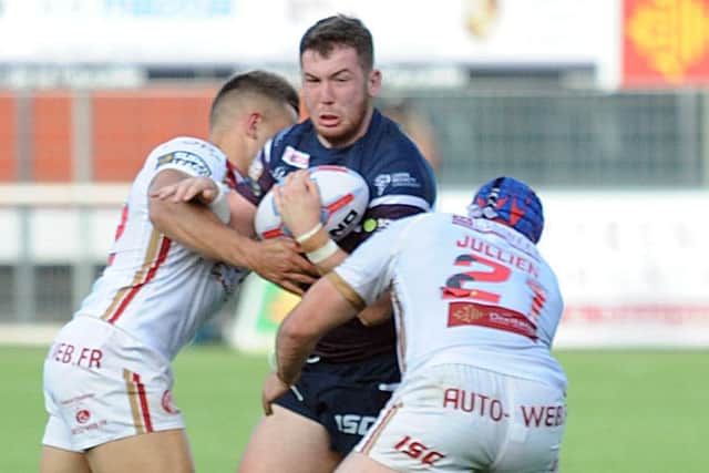 Leeds Rhinos' Cameron Smith is tackled by the Catalans Dragons' defence.