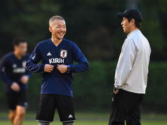 Yosuke Ideguchi speaks to Japan coach Akira Nishino.
